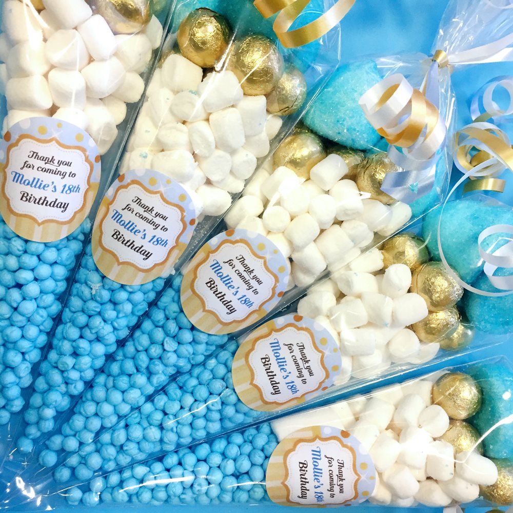 Assorted candy bags with blue, gold, and white colors and personalised labels.