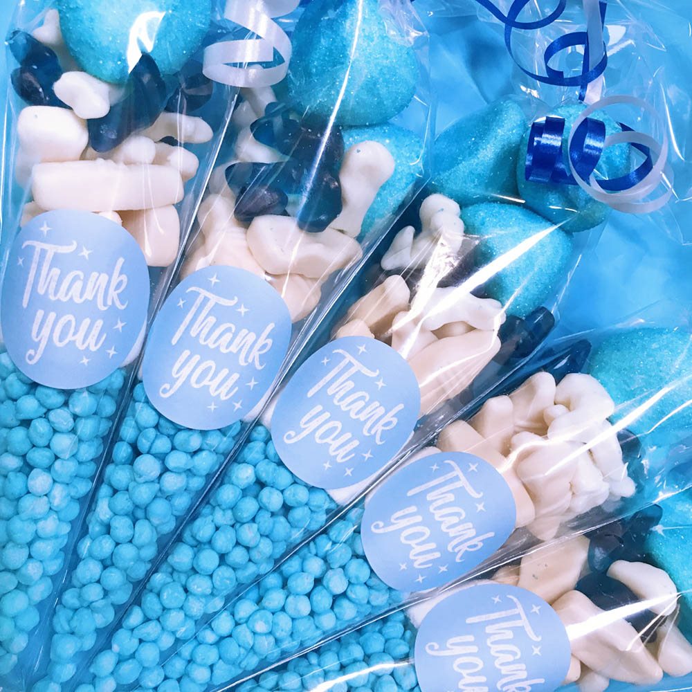 Packaged candies with 'Thank you' labels on sticks, featuring blue and white colors.