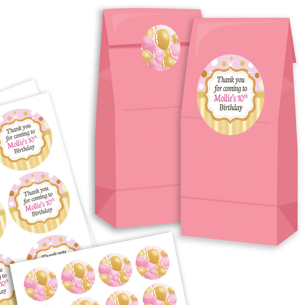 Pink goodie bags with personalized birthday stickers on a white background