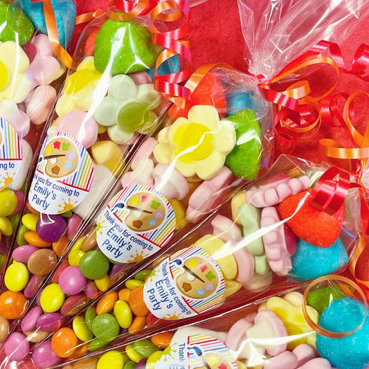 Colorful party favors with personalized labels on a red background