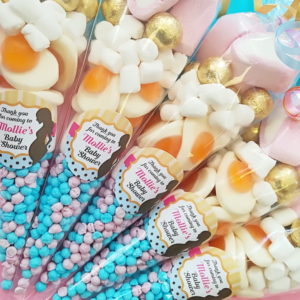 Assorted baby shower favors with personalized labels on a colorful background