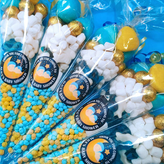 Baby shower favour bags with blue, yellow, and white candies and 'Thank you for coming to [child's name]' stickers.