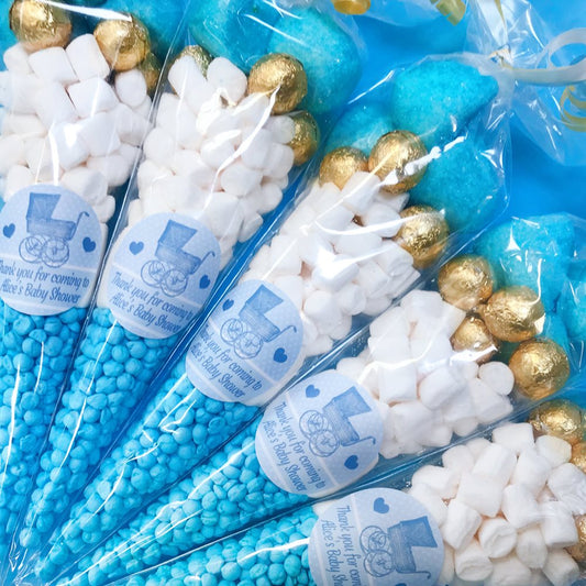 Baby shower candy cones with blue and gold decorations and white labels.
