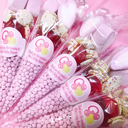 Decorative sweet cones with pink and white packaging for a baby shower.