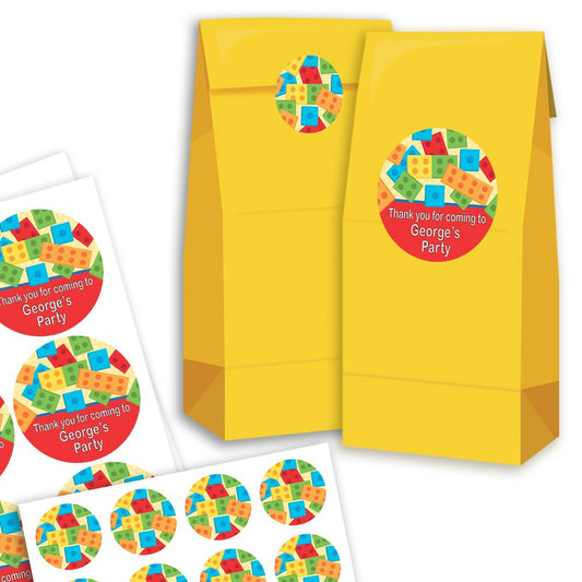 Yellow party favour bags with colourful geometric design labels on a white background