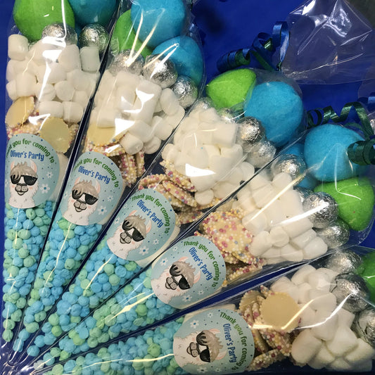 Assorted party favors in clear bags with personalized labels on a blue background