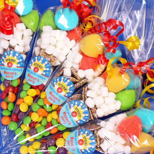 A selection of pre-filled sweet cones designed for bowling party favours, with various colorful candies visible inside the cones, sealed in transparent packaging.
