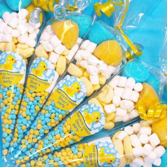 Pre-filled sweet cones with a rubber ducky theme, predominantly yellow and blue, with various candies visible inside.
