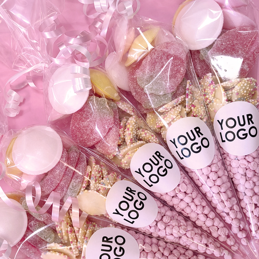 Assorted candies in clear bags with 'Your Logo' labels on a pink background