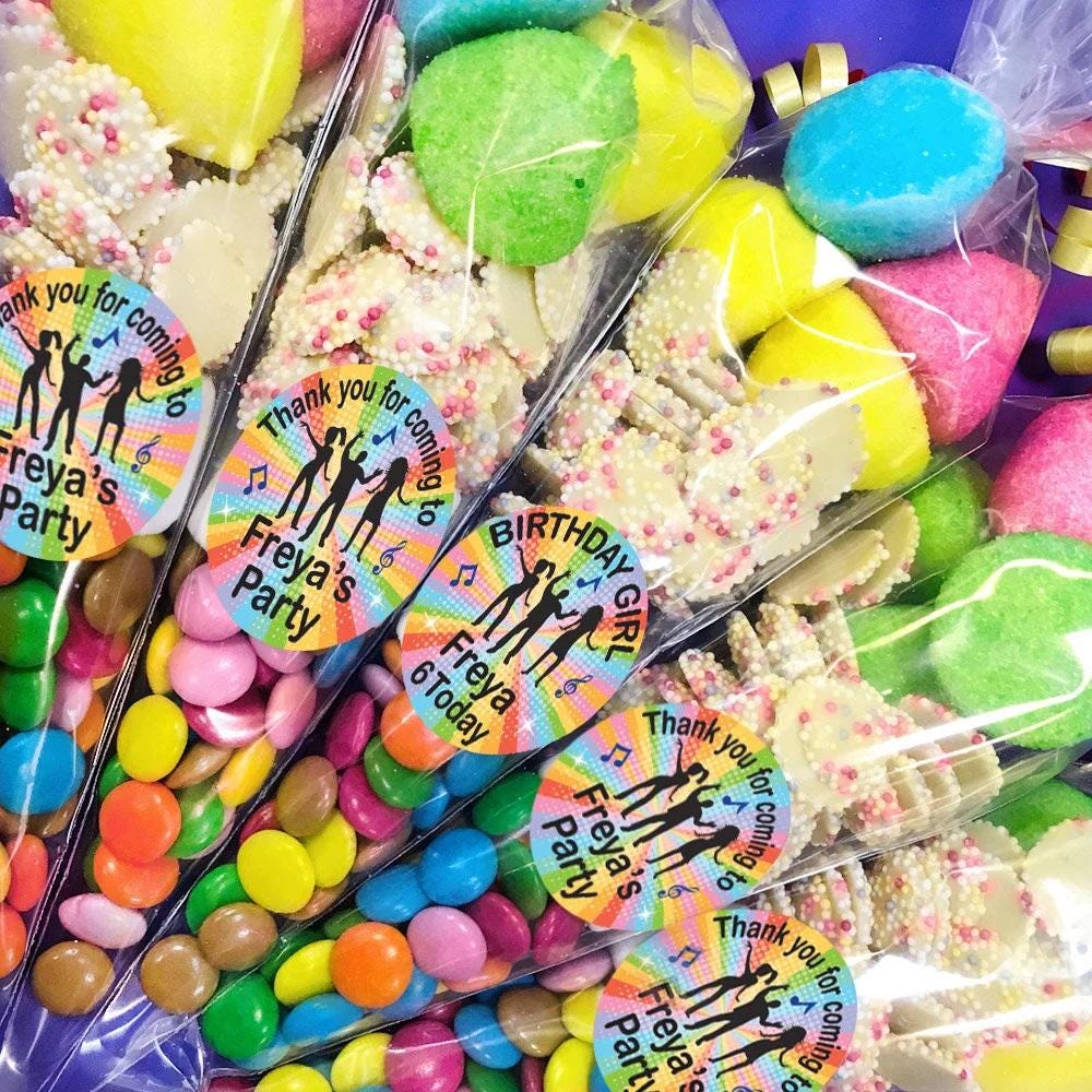 Pre-filled sweet cones with various colorful candies and personalized labels for a disco party.