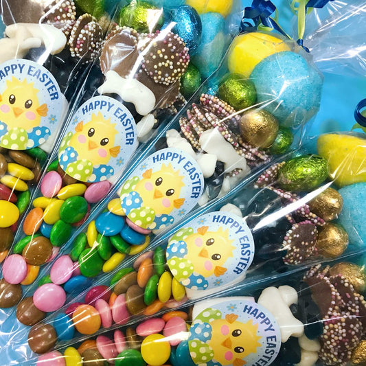 Assorted Easter candy in clear packages with 'Happy Easter' labels featuring cartoon chicks.