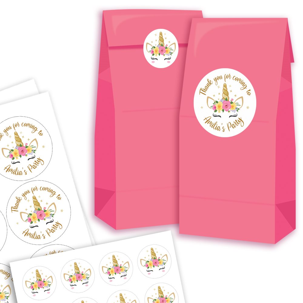 Pink party favour bags with personalised unicorn stickers on a white background