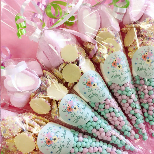 Decorative bouquet with pastel-colored candies and ribbons on a pink background