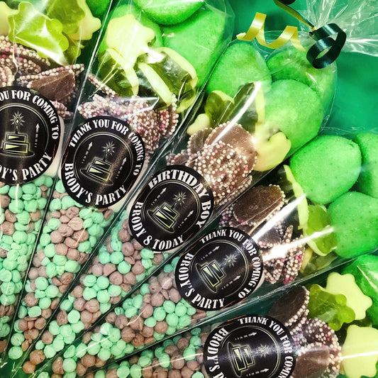 Green and brown candies in clear packaging with personalized labels on a green background