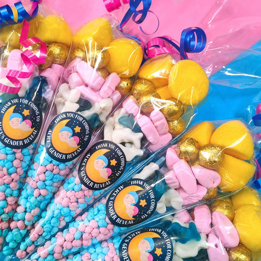 Sweet cone party favours of pink blue and yellow sweets with gender reveal themed stickers