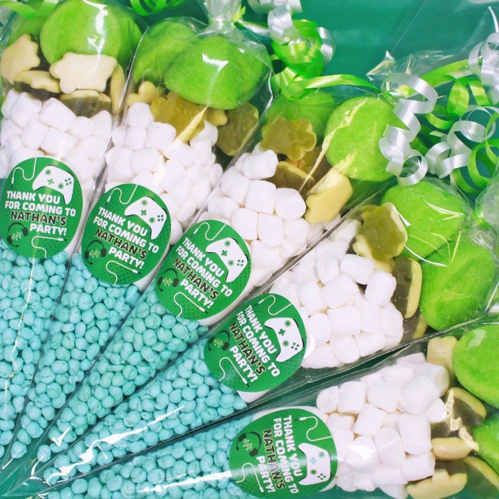 Pre-filled sweet cones with various candies visible through the packaging, labeled for a gamer-themed party, in green and white colors.
