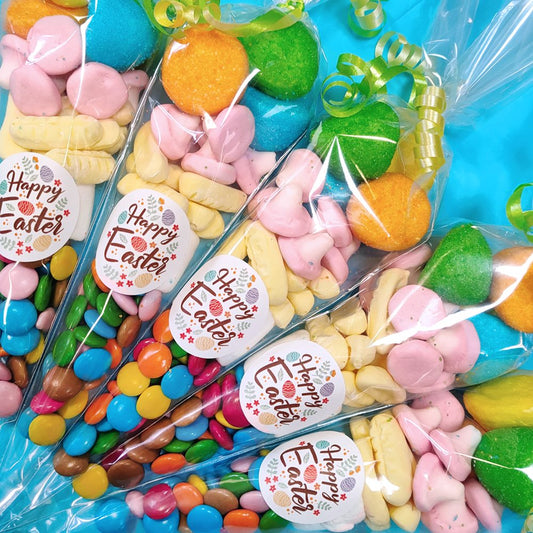 Colorful Easter candy in clear bags with 'Happy Easter' labels on a blue background.