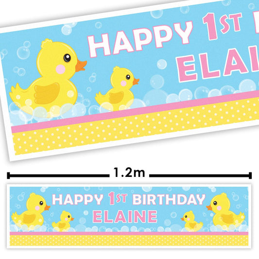 Birthday banner with yellow rubber duckies and text 'Happy 1st Birthday Elaine' on a blue background.