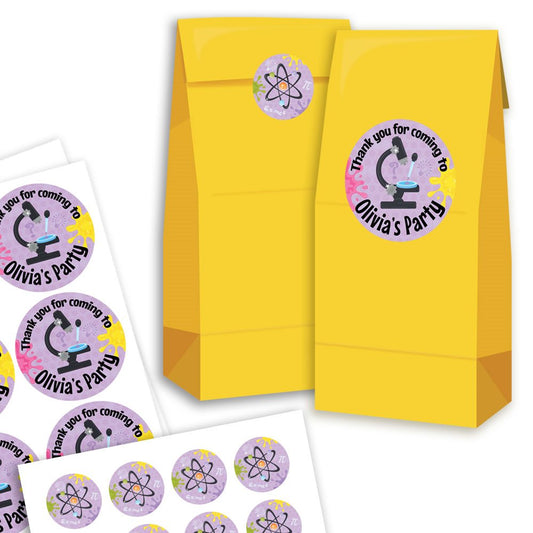 Yellow party favour bags with personalised stickers on a white background