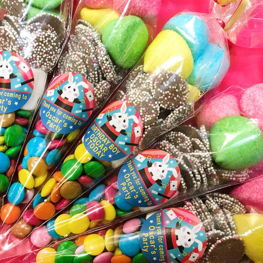 Colourful sweet cones with custom stickers depicting a rabbit in a hat for magician parties