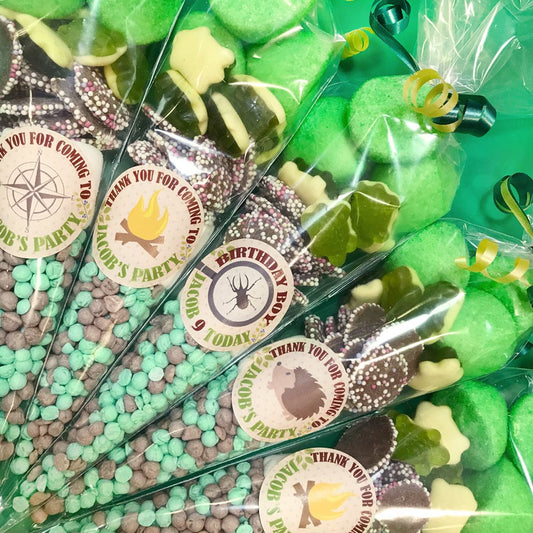 Party favors with personalized labels in clear packaging on a green background