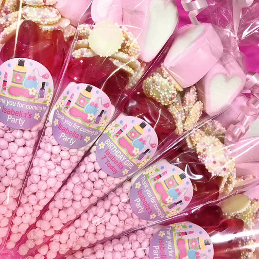 Pink and gold party favors with personalized labels on a clear background