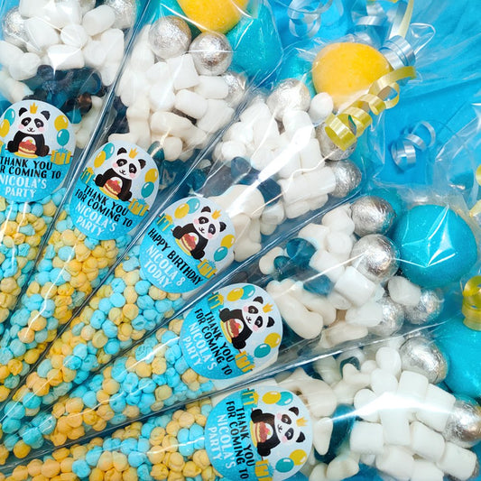 Party favors with panda-themed stickers and colorful candies.