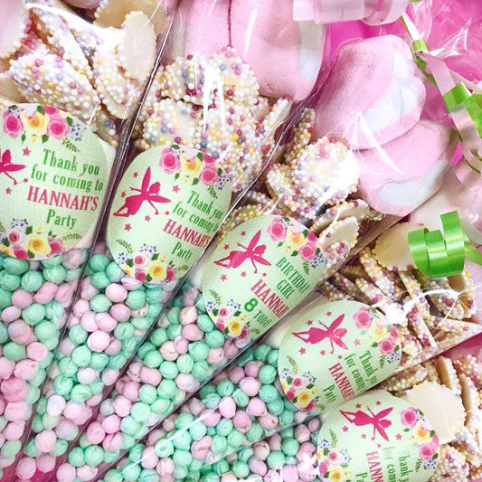 A close-up of a pre-filled sweet cone with a personalized label that reads 'Thank you for coming to Hannah's Party'. The cone is decorated with colorful candies and has a floral design on the label.