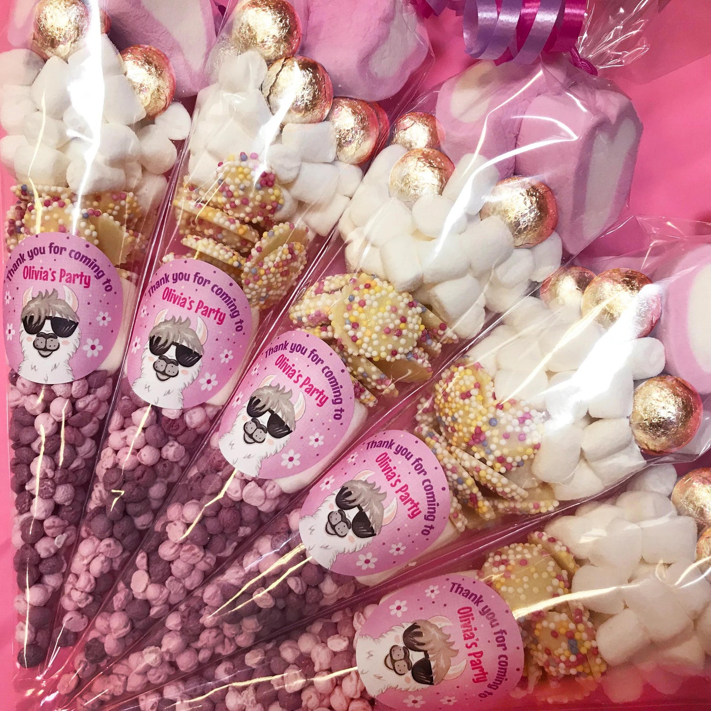 A collection of sweet cones with various candies and toppings, each labeled with a name and decorated in a pink theme, corresponding to a party favor concept.