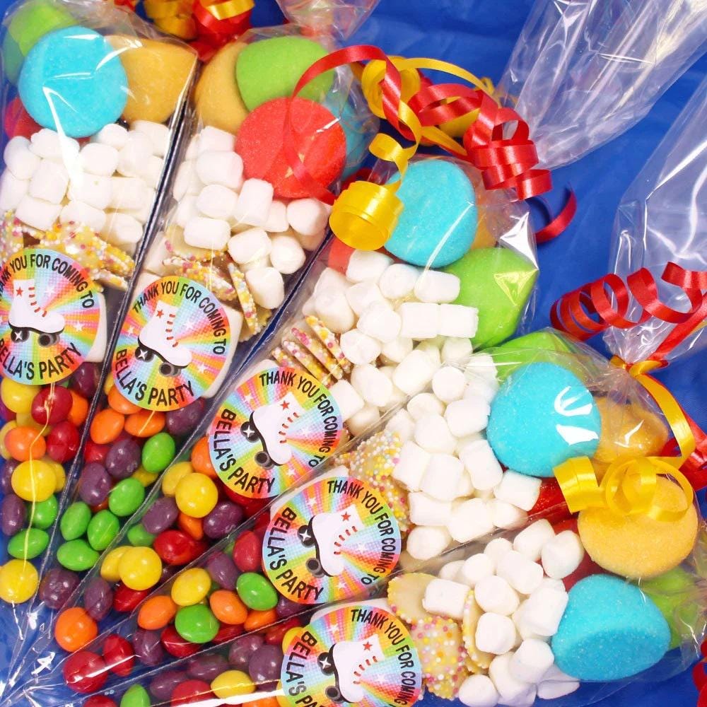 A colorful sweet cone containing various candies and personalized labels with names.