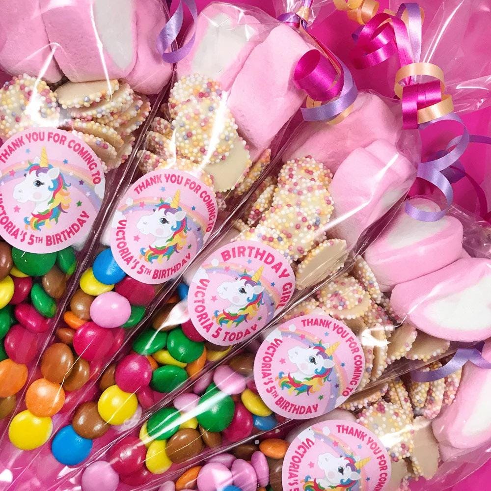 Pre-filled sweet cones in pink with various candies visible, decorated with birthday party labels.