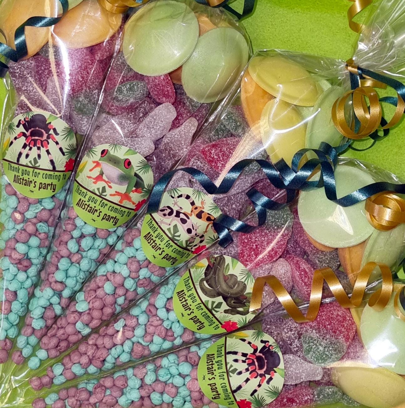 Packaged sweet cones with a variety of colorful candies visible through the transparent wrapping, each with a label that includes a name and感谢 you for coming to.
