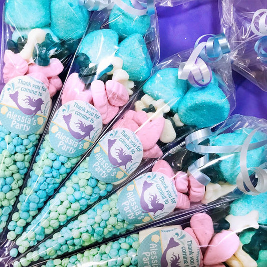 Colorful candy favors with mermaid-themed labels for a party.